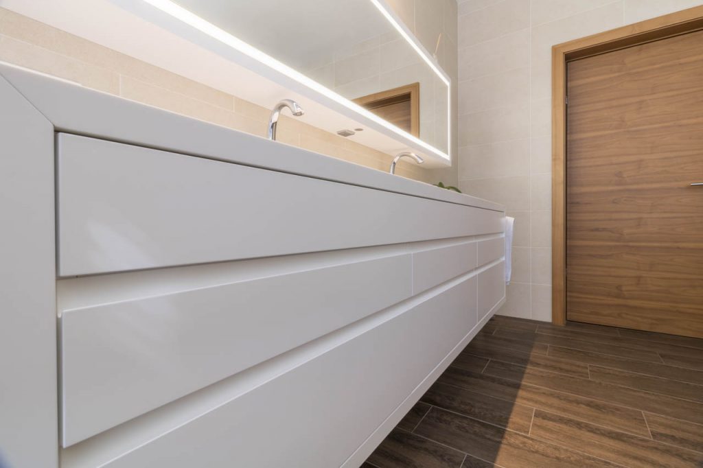 großer weiß lackierter Waschtischschrank mit beleuchtetem Spiegel